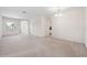 Spacious living room with neutral carpet, bright window, and interior hallway leading to other parts of the home at 6547 Castle Green Pl, Zephyrhills, FL 33541