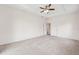 Spacious main bedroom with a ceiling fan, carpet flooring, and multiple doors at 6547 Castle Green Pl, Zephyrhills, FL 33541