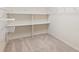 Spacious walk-in closet featuring carpeted floors and built-in shelving for optimal organization at 6547 Castle Green Pl, Zephyrhills, FL 33541