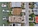 Aerial view of a waterfront house with a private dock and neatly manicured lawn at 811 Bay Point Dr, Madeira Beach, FL 33708