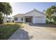 Charming single-story home with a well-maintained lawn, attached garage, and covered entrance at 811 Bay Point Dr, Madeira Beach, FL 33708