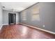 Bedroom featuring wood-look flooring, two windows, a ceiling fan, and a closet with black-out curtains at 8317 N Marks St, Tampa, FL 33604