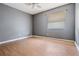 This bedroom features wood-look floors, a ceiling fan, and a window providing natural light at 8317 N Marks St, Tampa, FL 33604
