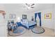 Charming bedroom with wood floors, ceiling fan, stylish rugs, furniture, and bright natural light at 905 W Fribley St, Tampa, FL 33603
