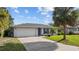 Inviting single-story home with a well-kept lawn, mature landscaping, and a paved driveway leading to an attached garage at 905 W Fribley St, Tampa, FL 33603