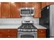Close up of stainless steel range, microwave, and wood cabinets in the kitchen at 905 W Fribley St, Tampa, FL 33603