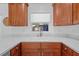 Kitchen area featuring a stainless steel sink, modern faucet, white countertops, and wood cabinets at 905 W Fribley St, Tampa, FL 33603