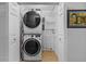 Laundry closet with stacked washer and dryer units, plus shelving for organization at 905 W Fribley St, Tampa, FL 33603