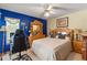 Cozy bedroom featuring a ceiling fan, wooden furniture, and a large window at 9202 Jena Rd, Spring Hill, FL 34608