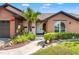 Inviting front exterior with a brick facade, landscaped garden, and walkway leading to a white front door at 9202 Jena Rd, Spring Hill, FL 34608