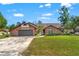 Charming single-story brick home with a well-manicured lawn and two-car garage, nestled under a blue sky with scattered clouds at 9202 Jena Rd, Spring Hill, FL 34608