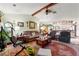 Open-concept living room with beamed ceiling, comfortable seating, and view into the kitchen at 9202 Jena Rd, Spring Hill, FL 34608