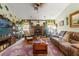 Inviting living room featuring a stone fireplace, wooden beams, and ample seating at 9202 Jena Rd, Spring Hill, FL 34608