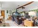 Cozy living room featuring a fireplace, beamed ceiling, and comfortable seating at 9202 Jena Rd, Spring Hill, FL 34608