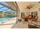Inviting screened lanai with a sparkling pool, comfortable seating, and a ceiling fan for relaxation at 9202 Jena Rd, Spring Hill, FL 34608