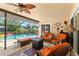 Relaxing screened lanai boasts a refreshing pool, cozy furniture, and a delightful ceiling fan for comfort at 9202 Jena Rd, Spring Hill, FL 34608