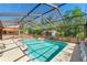 Large screened-in pool with fun floats, a convenient bar area, and lush backyard scenery at 9202 Jena Rd, Spring Hill, FL 34608