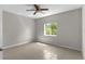 Bright bedroom featuring tile flooring, a ceiling fan, and a large window with a green view at 9519 Newdale Way # 202, Riverview, FL 33578
