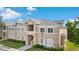 Beautiful condo building with tan exterior, white trim, and surrounding greenery at 9519 Newdale Way # 202, Riverview, FL 33578