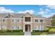 Inviting condo building with tan exterior, white trim, well-maintained landscaping, and visible unit number at 9519 Newdale Way # 202, Riverview, FL 33578