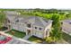 A multi-Gathering property featuring beige siding, a gray roof, and well-manicured landscaping at 9519 Newdale Way # 202, Riverview, FL 33578