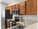 Modern kitchen featuring stainless steel appliances, wood cabinets, and a sleek faucet at 9519 Newdale Way # 202, Riverview, FL 33578