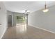 Spacious living room with tile flooring, neutral walls, ceiling fan, and sliding glass doors to balcony at 9519 Newdale Way # 202, Riverview, FL 33578