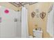 Well-lit bathroom featuring a shower with a white shower curtain, a toilet, and decorative art at 10311 Frog Pond Dr, Riverview, FL 33569