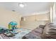 Bright bonus room featuring neutral walls, plush carpeting, and a floral area rug near a brown leather sofa at 10311 Frog Pond Dr, Riverview, FL 33569