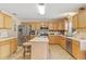 A bright kitchen with light wood cabinetry, an island and stainless steel appliances at 10311 Frog Pond Dr, Riverview, FL 33569