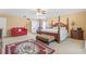 Spacious main bedroom features a four-poster bed, sitting area, and a ceiling fan for added comfort at 10311 Frog Pond Dr, Riverview, FL 33569
