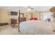 Bright main bedroom featuring a TV, a four-poster bed, and a neutral color scheme at 10311 Frog Pond Dr, Riverview, FL 33569