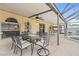 Covered patio with outdoor dining set and serene views of the screened-in pool at 10311 Frog Pond Dr, Riverview, FL 33569