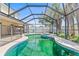 Backyard paradise featuring a screened pool, spa, outdoor seating, and landscaped yard at 10311 Frog Pond Dr, Riverview, FL 33569
