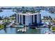 Panoramic aerial view of a waterfront condo building with a pool, boat docks and stunning coastal scenery at 10355 Paradise Blvd # 502, Treasure Island, FL 33706
