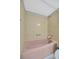 Close up of a pink tub and neutral tiled walls at 10355 Paradise Blvd # 502, Treasure Island, FL 33706
