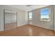 Bedroom showcases hardwood floors, mirrored closet doors, and sunny windows with pleasant views at 10355 Paradise Blvd # 502, Treasure Island, FL 33706