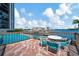Outdoor deck area with table and chairs overlooking the pool and marina at 10355 Paradise Blvd # 502, Treasure Island, FL 33706