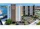 Exterior corner view of the Paradise Island Towers with covered parking, lush tropical landscaping, and marina at 10355 Paradise Blvd # 502, Treasure Island, FL 33706