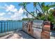 Outdoor barbecue area with a built-in grill and serene waterfront views at 10355 Paradise Blvd # 502, Treasure Island, FL 33706