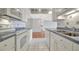 Well-lit kitchen featuring white cabinetry, tile backsplash, modern appliances, and an open layout at 10355 Paradise Blvd # 502, Treasure Island, FL 33706