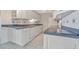 Kitchen features white cabinets, tile flooring, and a modern dishwasher for convenience at 10355 Paradise Blvd # 502, Treasure Island, FL 33706