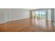 Bright living room with gleaming hardwood floors and sliding glass doors to a sunny balcony at 10355 Paradise Blvd # 502, Treasure Island, FL 33706