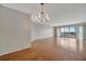 Spacious living room with wood floors, a modern chandelier, and sliding glass doors leading to a balcony at 10355 Paradise Blvd # 502, Treasure Island, FL 33706