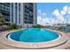 Community swimming pool with lounge chairs and marina views by the condo building at 10355 Paradise Blvd # 502, Treasure Island, FL 33706