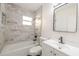 Beautiful bathroom showcasing patterned backsplash, a shower-tub combo, and modern sink at 10733 Drummond Rd, Tampa, FL 33615