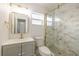 Updated bathroom with gold hardware and walk-in shower featuring stone tile and glass doors at 10733 Drummond Rd, Tampa, FL 33615