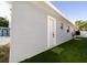 Exterior shot of the home with a door, painted stucco and artificial turf at 10733 Drummond Rd, Tampa, FL 33615