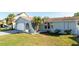 Well-maintained one-story home with a lawn, attached garage, and welcoming palm trees at 10733 Drummond Rd, Tampa, FL 33615