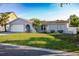 Lovely single-story home featuring a manicured lawn, attached garage, and mature palm trees at 10733 Drummond Rd, Tampa, FL 33615